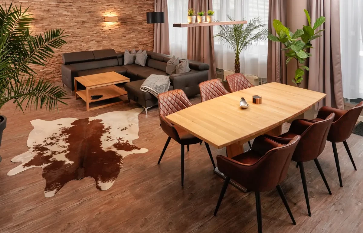 Wohnzimmer des Paradise Apartments in Leipzig, stilvoll mit Couch und Essbereich eingerichtet, spiegelt die einzigartige Themengestaltung und Liebe zum Detail wider, die jeden Aufenthalt unvergesslich macht.