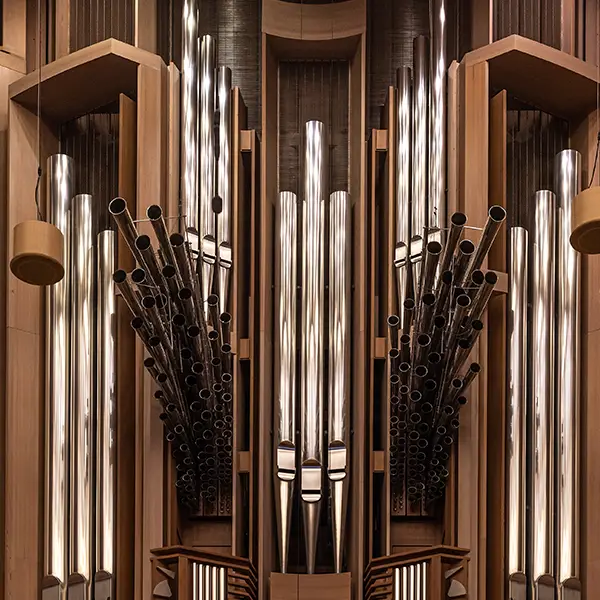 roße Orgel mit glänzenden Metallpfeifen in einem hölzernen Gehäuse, symmetrisch aufgebaut und komplex in ihrer Gestaltung.
