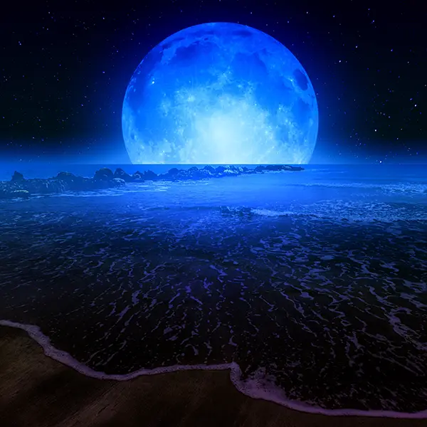 Eine nächtliche Strandszene mit einer riesigen, leuchtend blauen Vollmondkugel, die über dem Horizont aufzugehen scheint, und reflektierendem Wasser im Vordergrund.